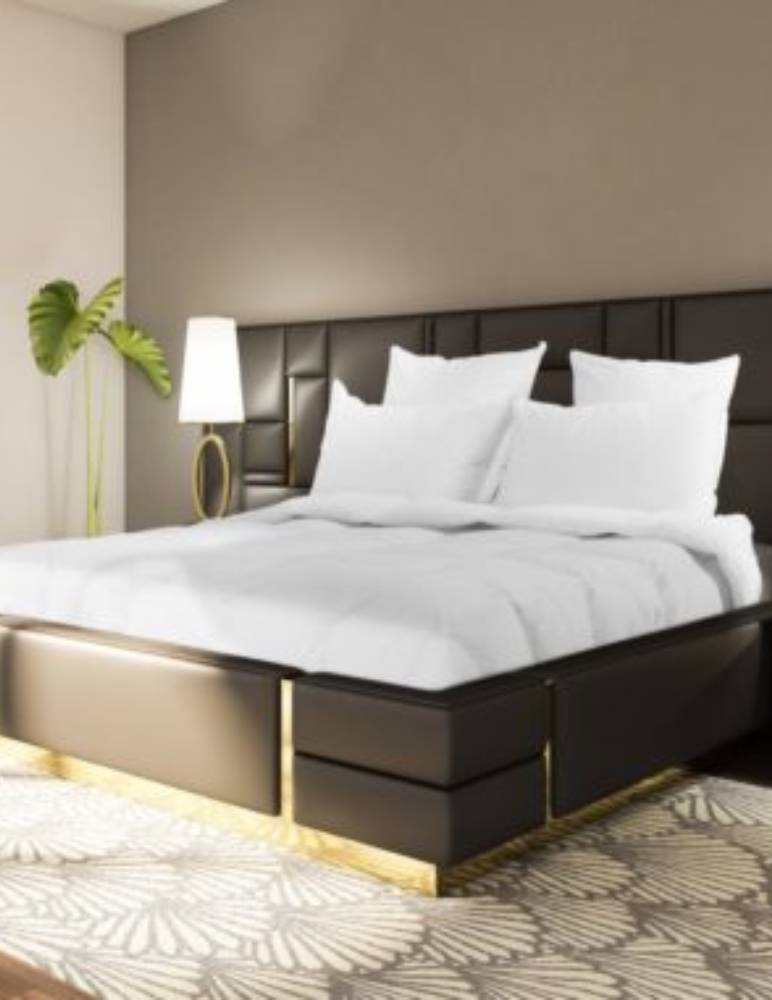 Luxurious white bedding and pillows displayed on a bed in a serene, calming bedroom setting with soft lighting and elegant decor